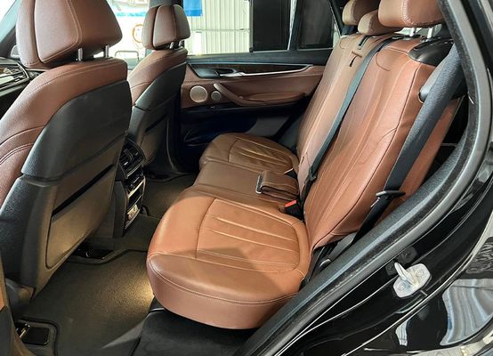 the back seat of a black bmw x5 with brown leather seats